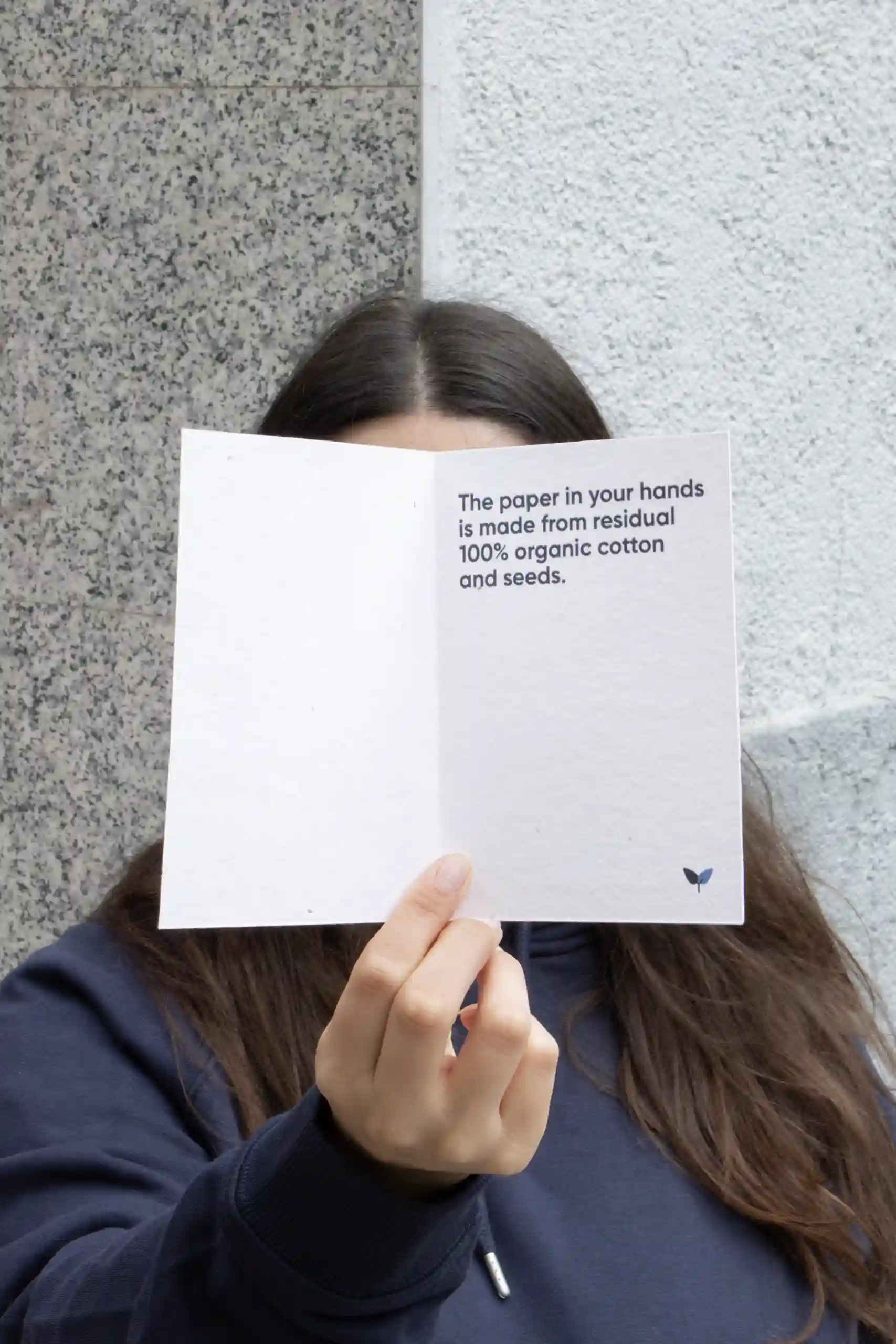 Carte pliante A6 plantable Chica mostrando a cámara un díptico A6 impreso en papel plantable