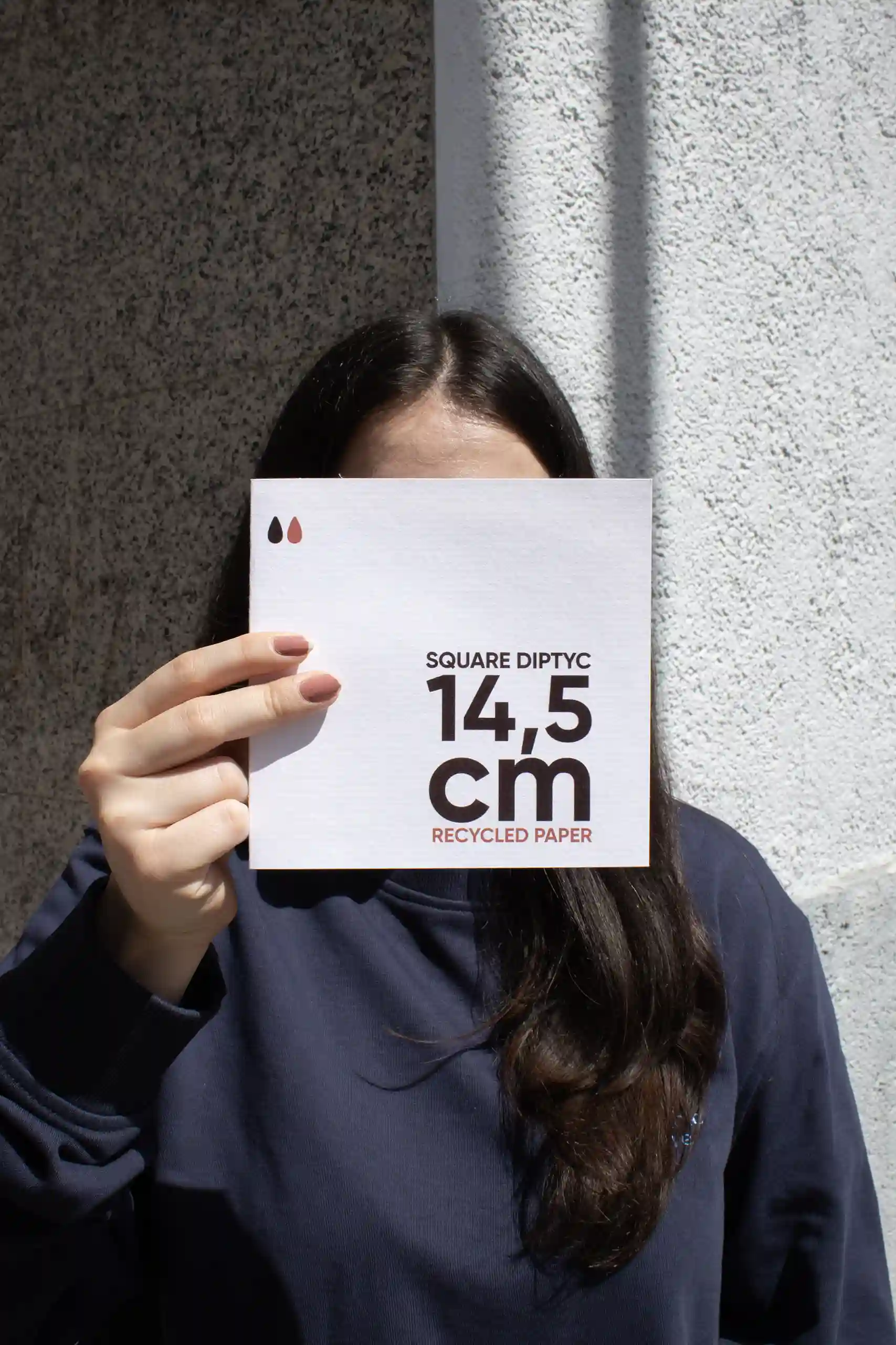 Díptico de papel ecológico cuadrado Chica mostrando a cámara un díptico cuadrado impreso en papel ecológico