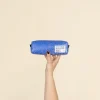 Mano mostrando un estuche de lona reciclada de color azul y naranja