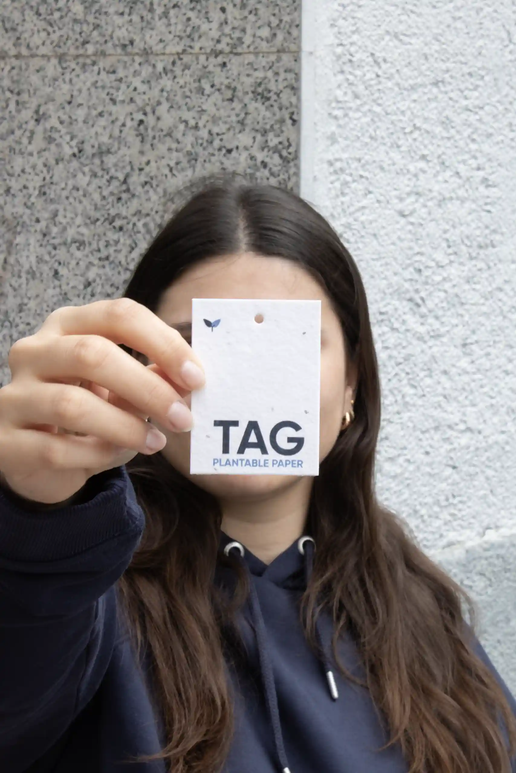 Seed paper tags Chica mostrando a cámara una etiqueta de ropa impresa en papel plantable