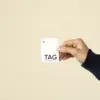 Mano mostrando una etiqueta de ropa impresa en papel plantable