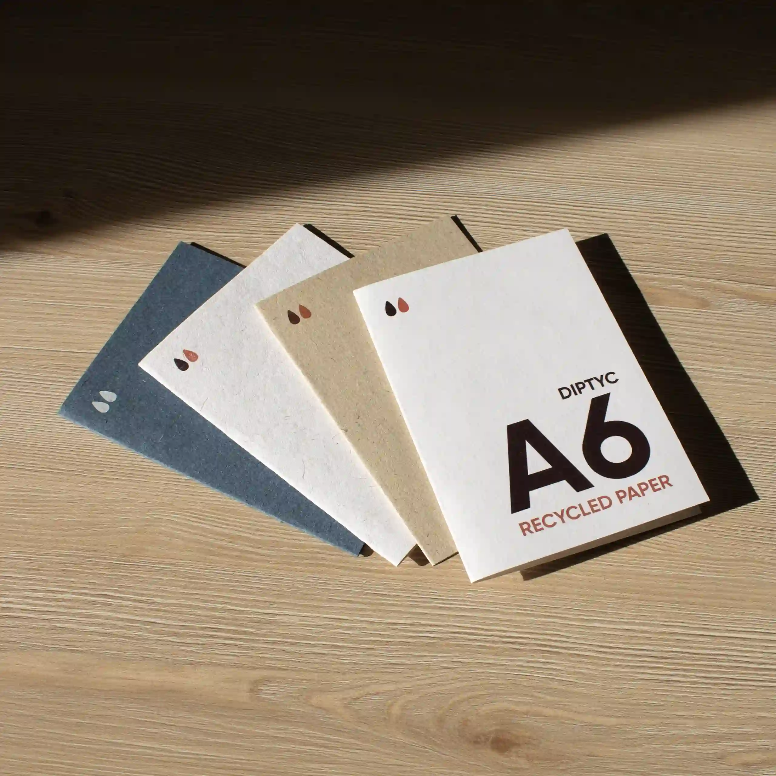Carte pliante A6 en papier écologique Cuatro dípticos A6 impresos en papel ecológico sobre una superficie de madera