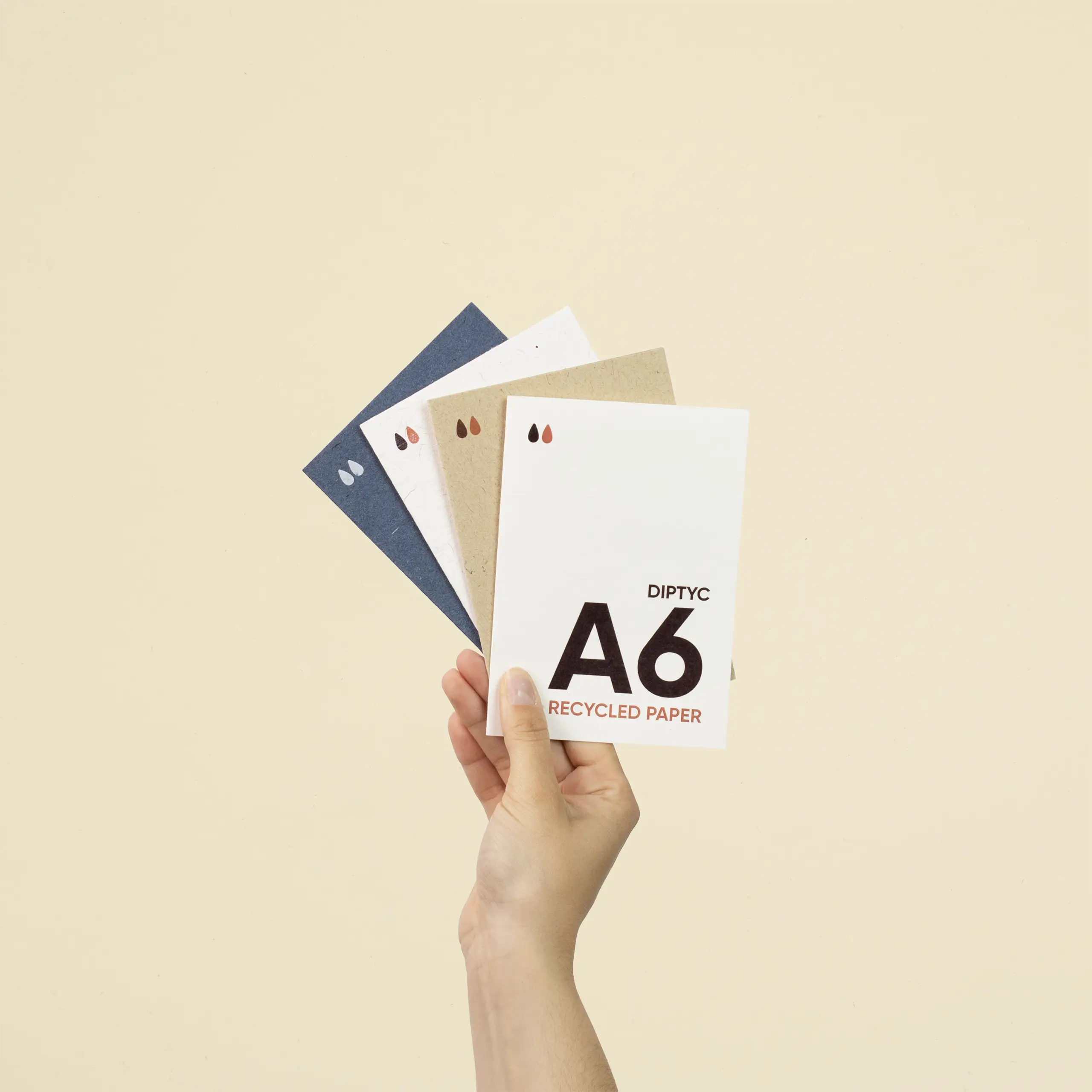 Díptico A6 de papel ecológico Una mano sujetando cuatro dípticos A6 impresos en papel ecológico