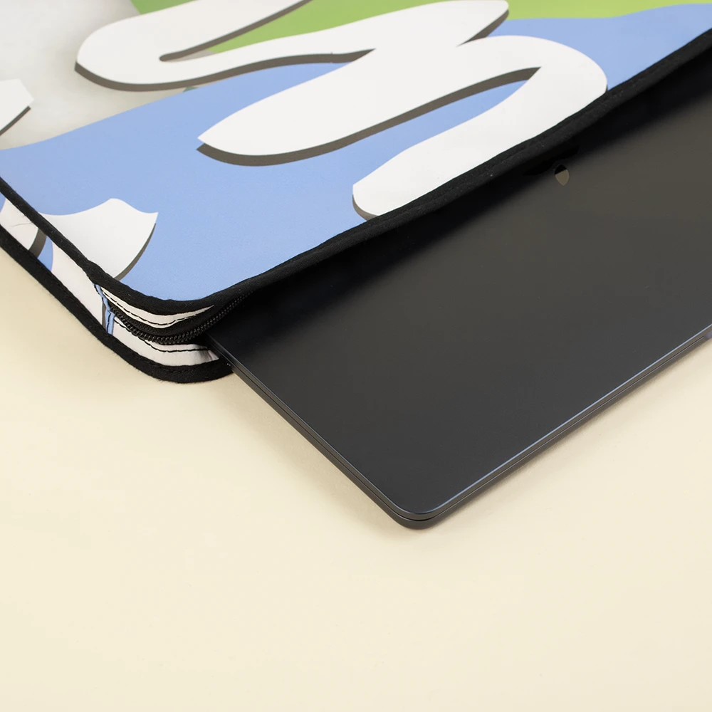 Funda de portátil ecológica de lona LISA Funda de portátil personalizada hecha con lona reciclada abierta junto a un portátil de color negro