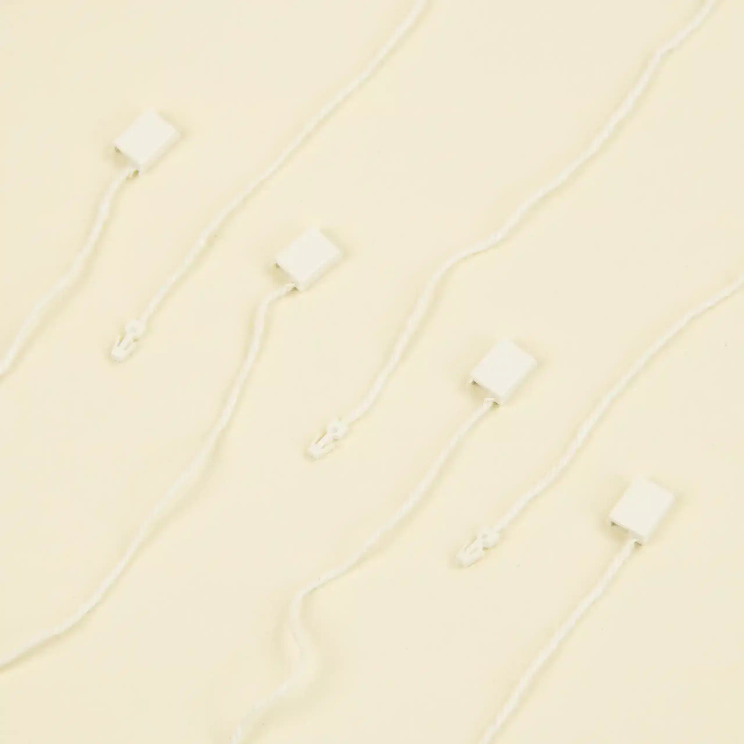 Marchamos biodegradables 7 marchamos biodegradables blancos colocados sobre una superficie beige