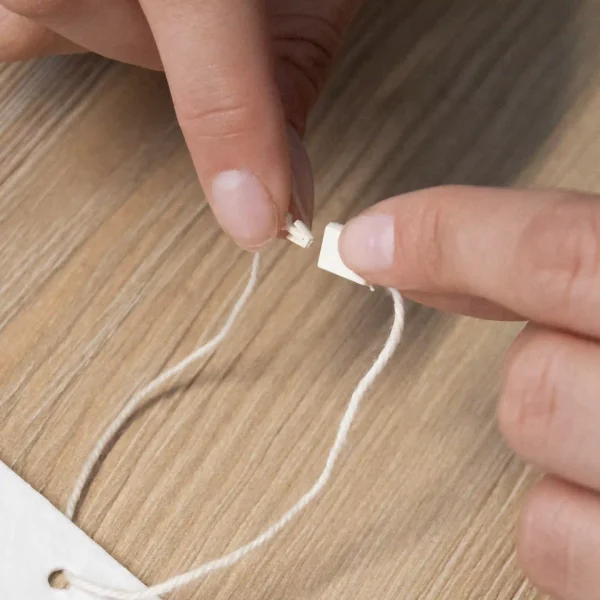 Dos manos cerrando un marchamo biodegradable