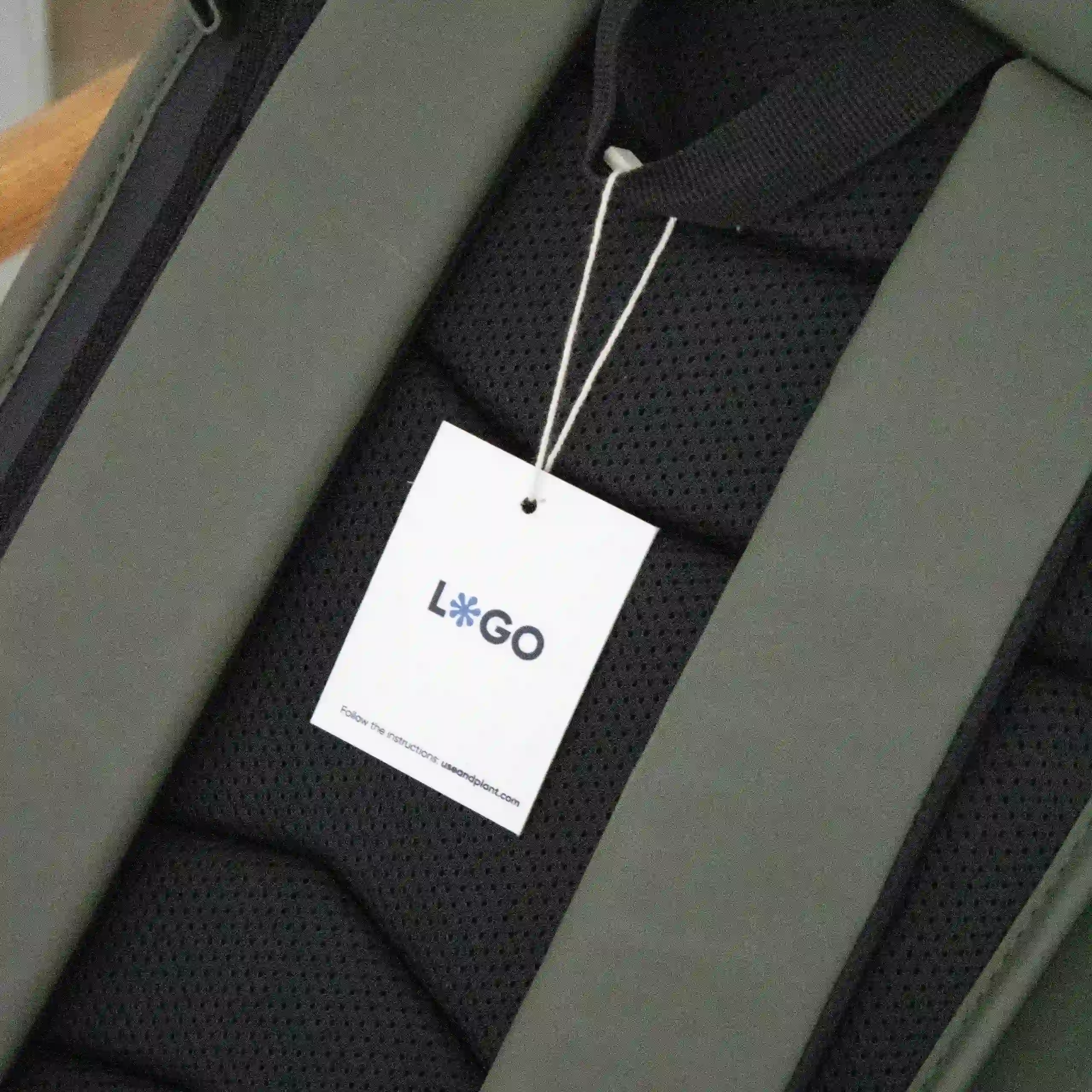 Marchamos biodegradables Etiqueta impresa en papel plantable con un marchamo biodegradable blanco colgada de una mochila verde