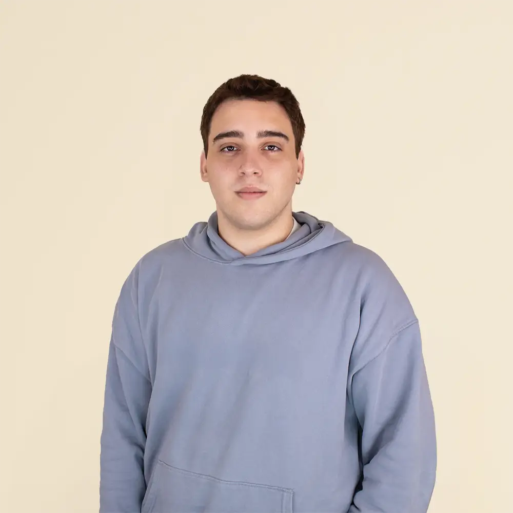 Chico moreno de frente llevando jeans y una sudadera blanca con capucha personalizada