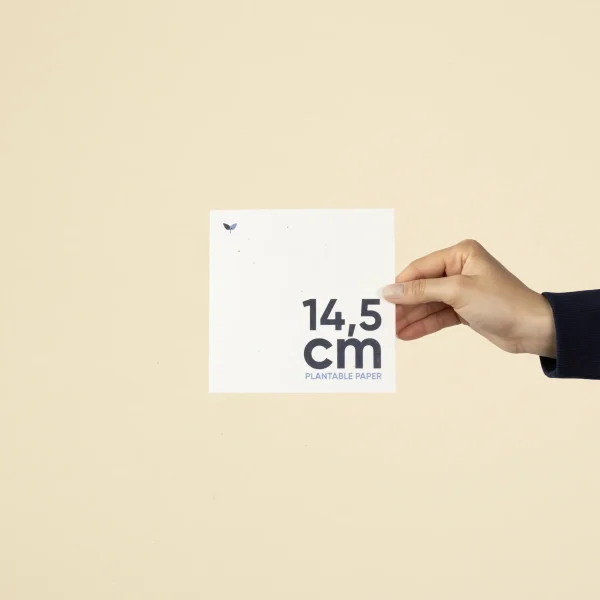 Mano mostrando una tarjeta cuadrada impresa en papel plantable
