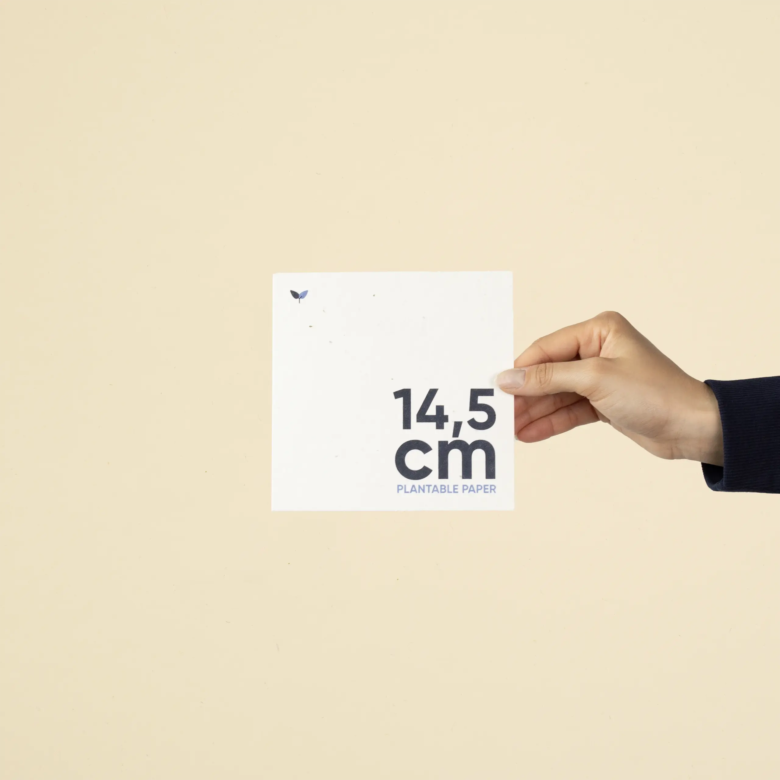 Mano mostrando una tarjeta cuadrada impresa en papel plantable