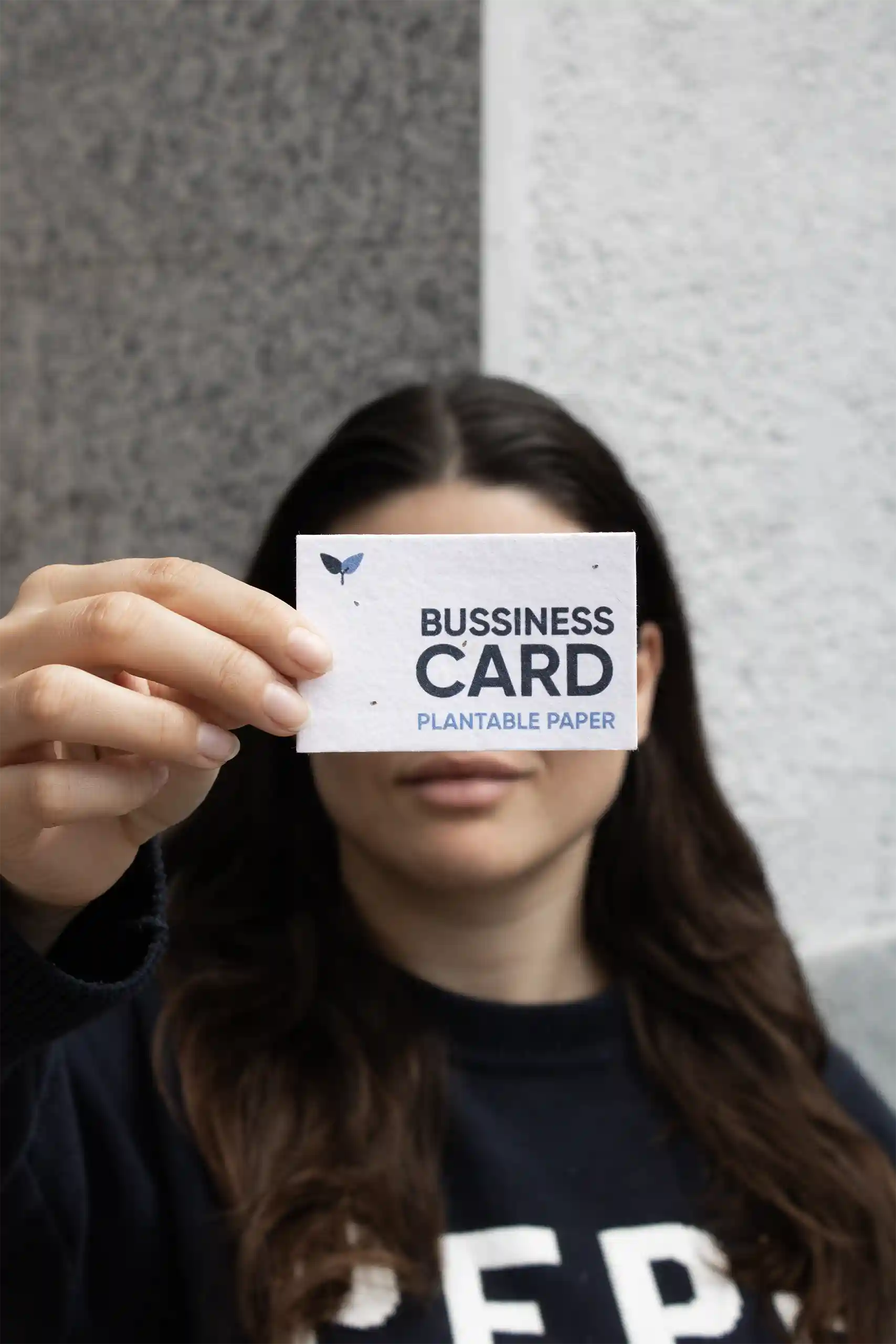 Seed paper business card Chica mostrando a cámara una tarjeta de visita impresa en papel plantable