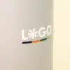 Primer plano de vaso térmico gris de acero inoxidable con logo sobre un fondo beige