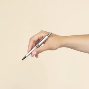 Mano sujetando un bolígrafo plateado de aluminio reciclado personalizado con la palabra LOGO en azul oscuro