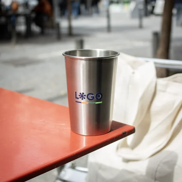 Vaso de acero inoxidable personalizado sobre mesa roja