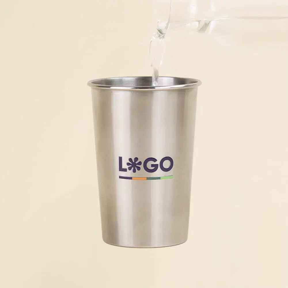 Botella sirviendo agua sobre vaso de acero inoxidable personalizado