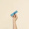 Mano mostrando un llavero azul hecho con lona reciclada