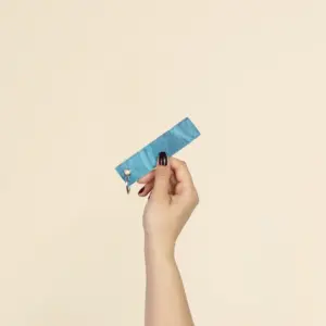 Mano mostrando un llavero azul hecho con lona reciclada