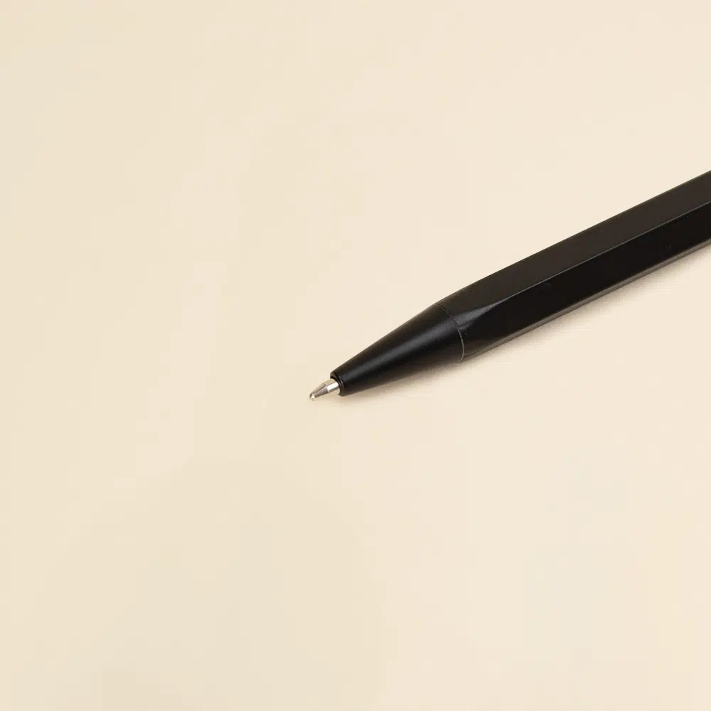 Bolígrafo hexagonal de aluminio SIXTO Primer plano de bolígrafo de aluminio sobre una superficie beige