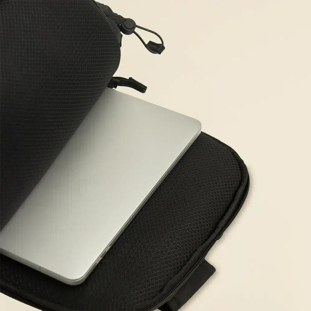 Mochila urbana personalizada FORMA negra Portátil guardado en mochila abierta urbana personalizada negra sobre un fondo beige