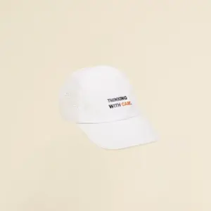 Gorra con visera personalizable blanca en fondo beige