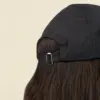 Parte trasera de gorra personalizable con visera deportiva sobre un fondo beige
