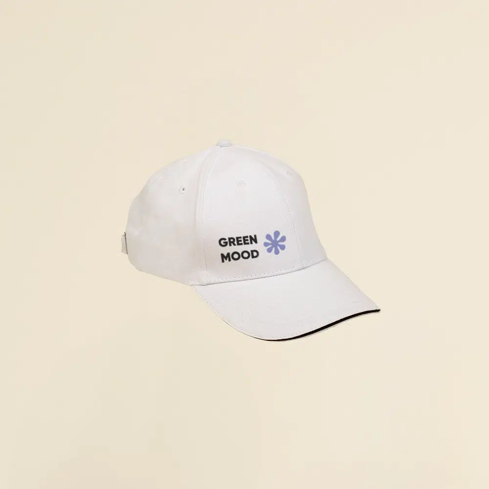 Gorra blanca con logo lateral en un fondo beige