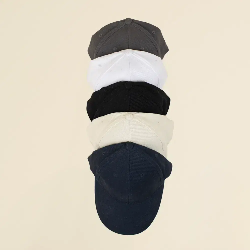 Gorra con logo MONDRA Cinco gorras de colores en fila en un fondo beige