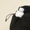 Botella blanca en uno de los bolsillos de una bolsa de deporte negra de poliéster reciclado
