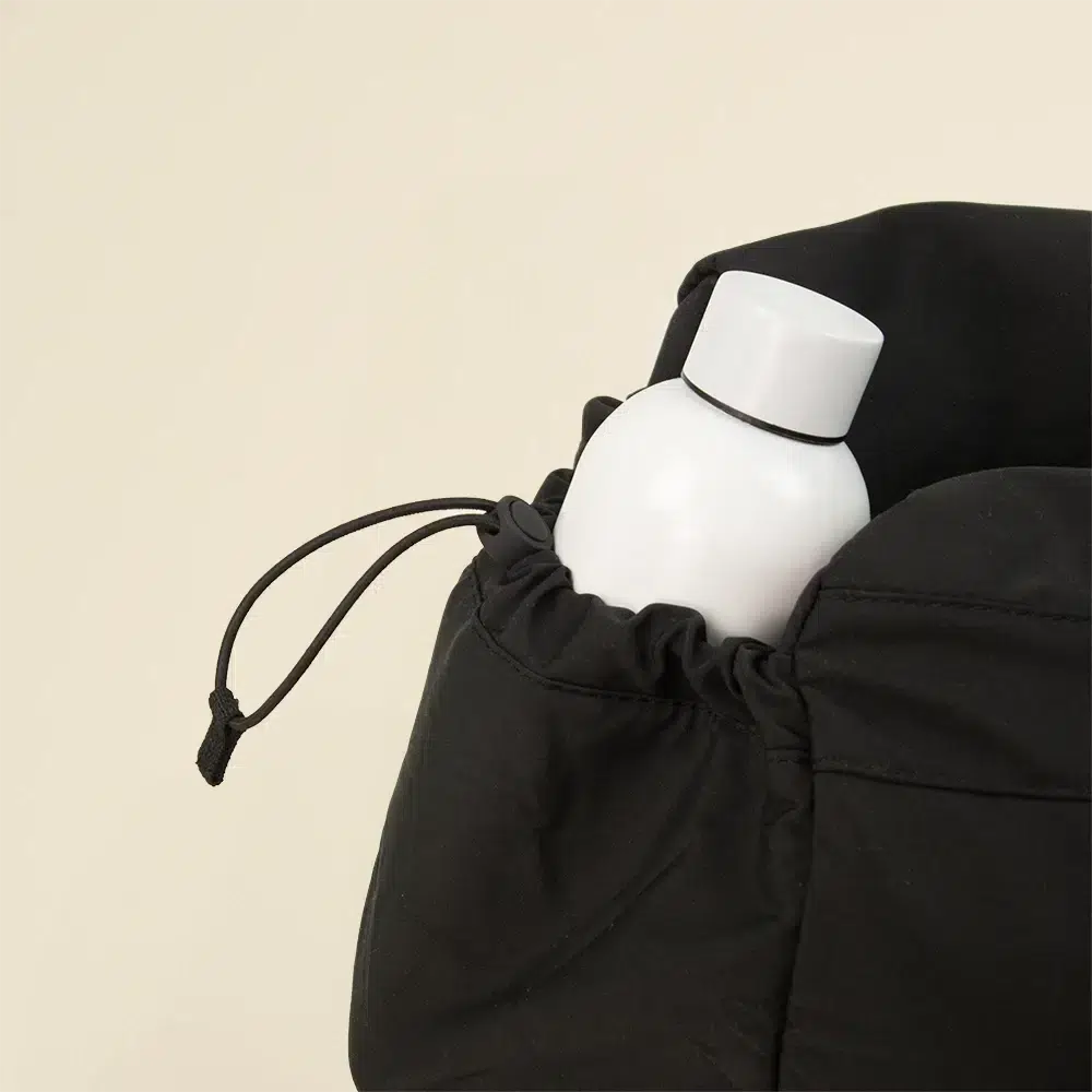 Bolsa de deporte PULSE Botella blanca en uno de los bolsillos de una bolsa de deporte negra de poliéster reciclado