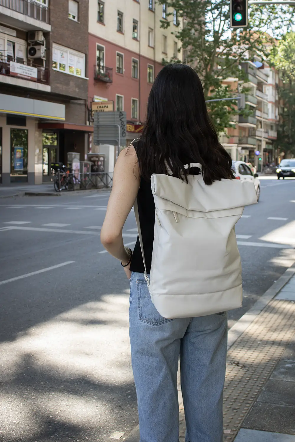 Mochila roll top personalizada ROLA Chica al cruzar la calle con una mochila roll top personalizada blanca