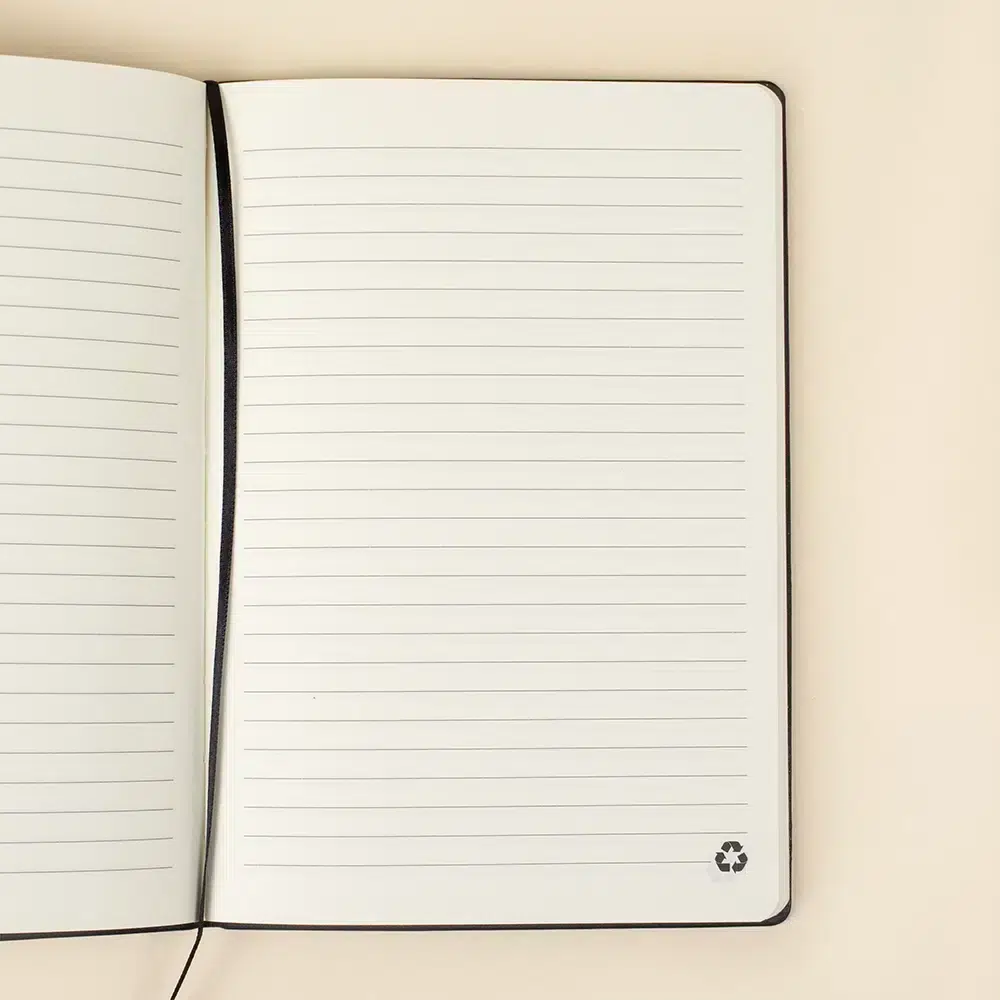 Cuaderno ecológico personalizado TREZO Cuaderno ecológico personalizado abierto sobre una superficie beige