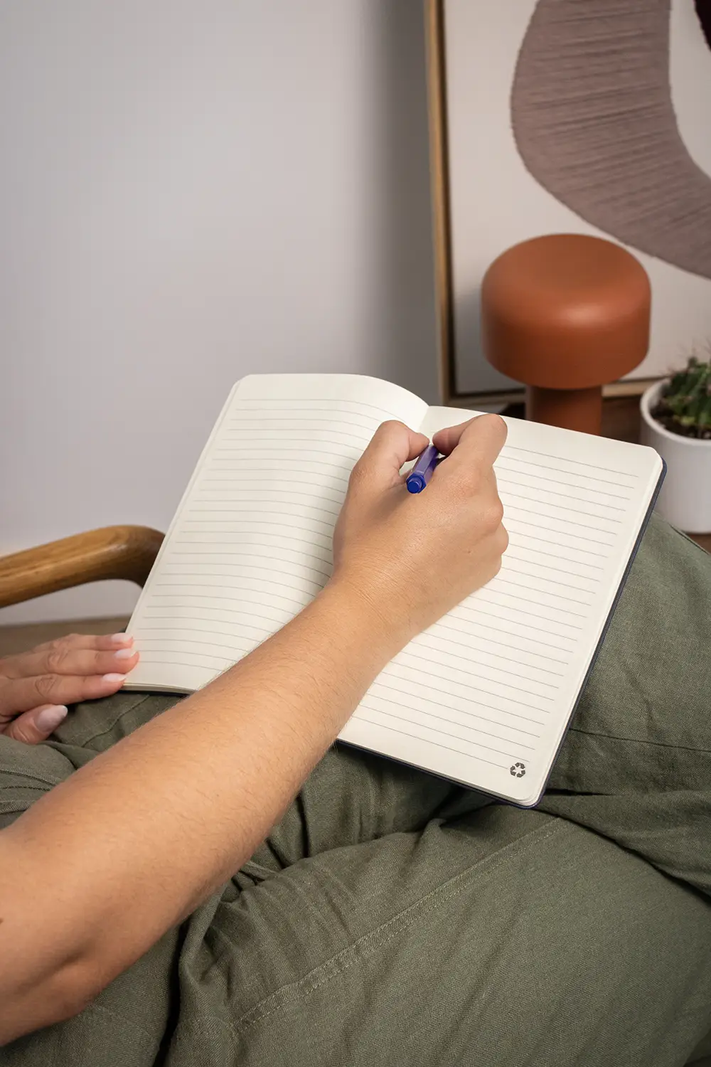 Mano con bolígrafo escribiendo sobre un cuaderno ecológico personalizado
