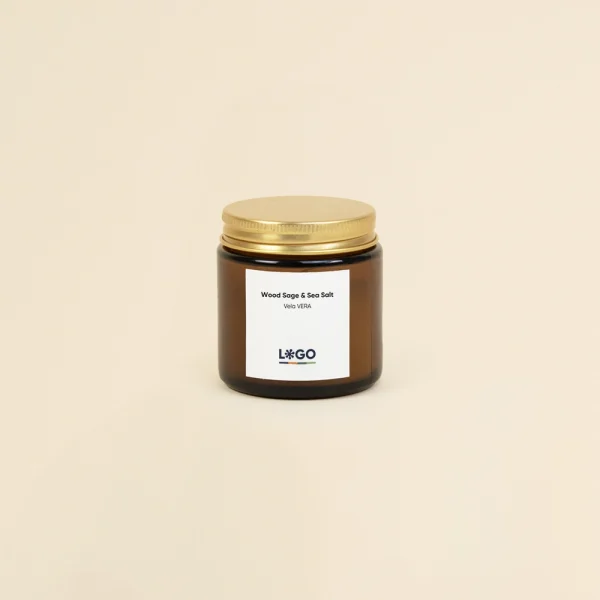 Vela aromática personalizada con tapa metálica sobre un fondo beige