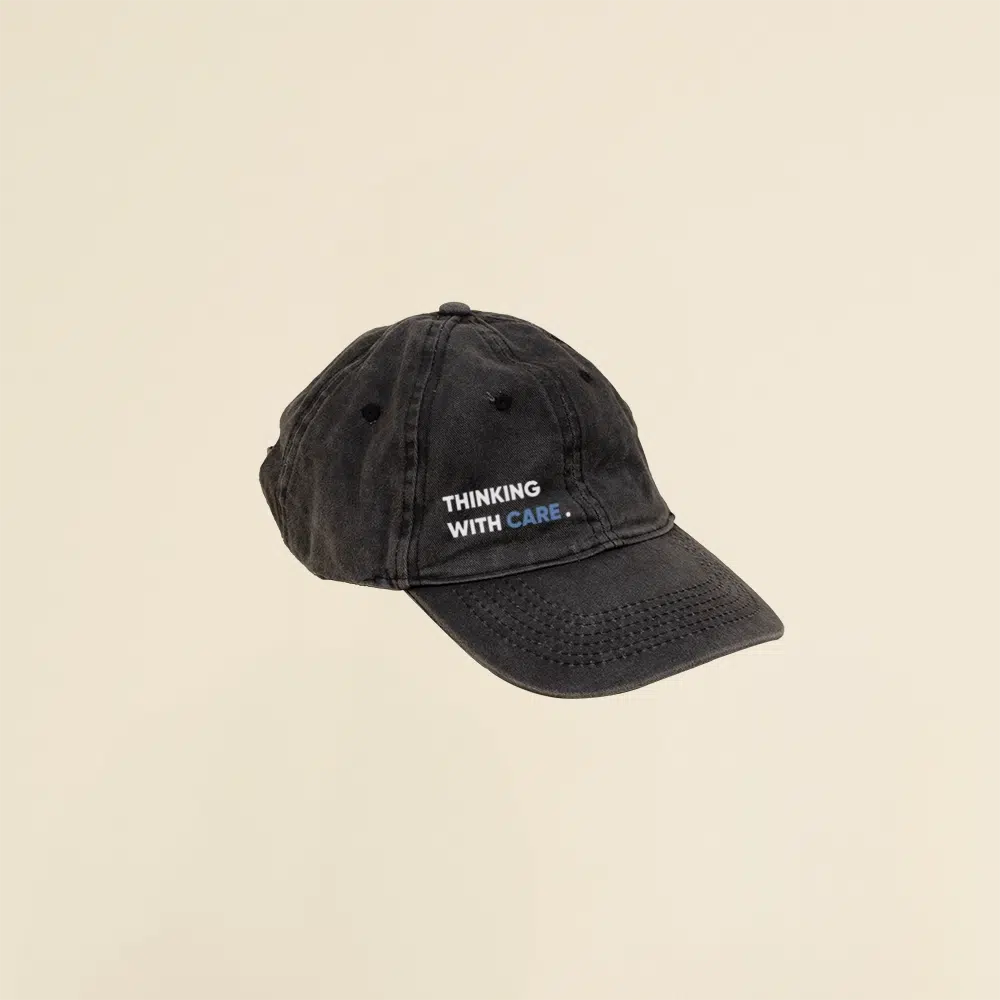 Gorra vintage negra con logo en un fondo beige
