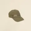 Gorra vintage verde con logo en un fondo beige
