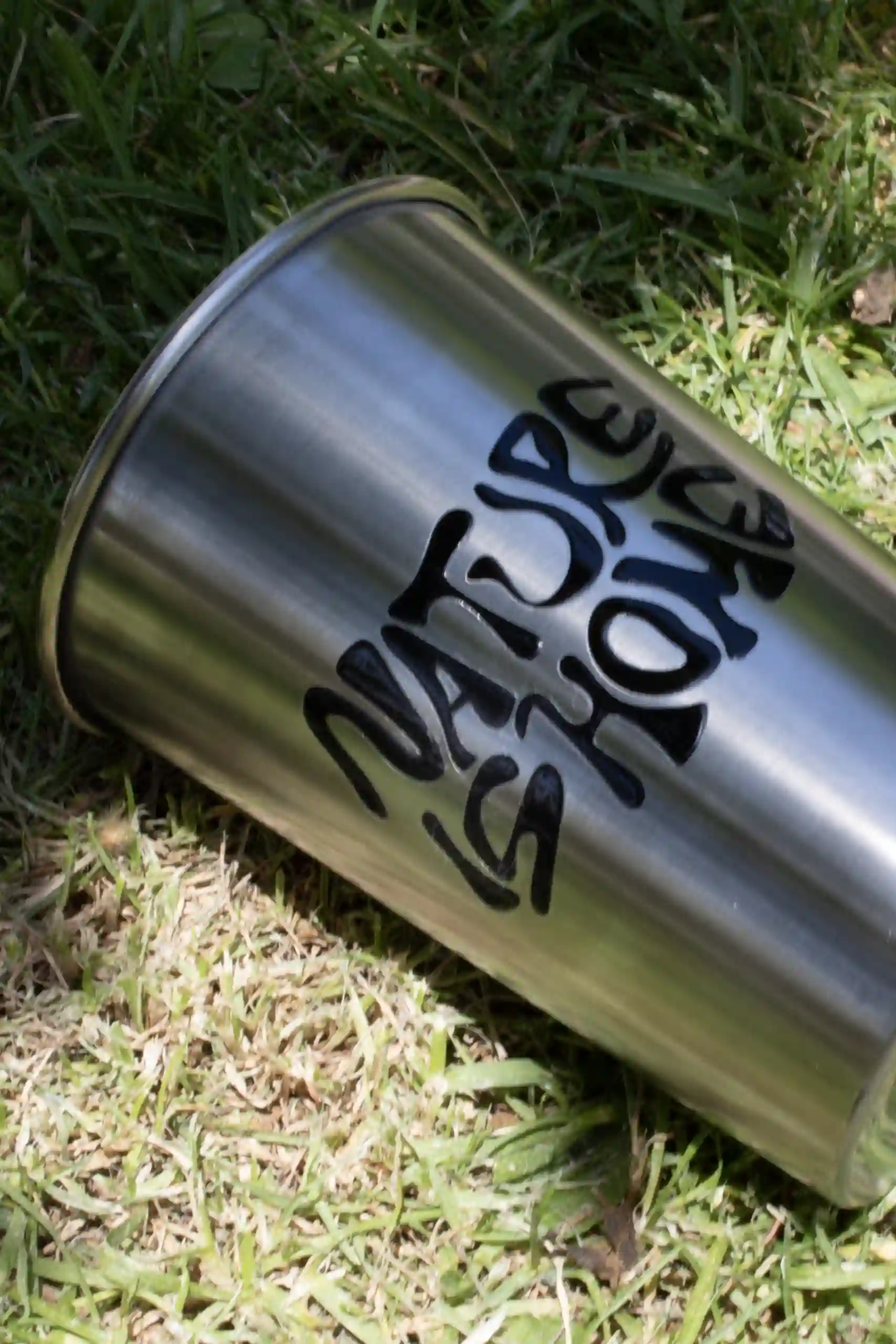 Vaso de acero inoxidable personalizado sobre un suelo de césped