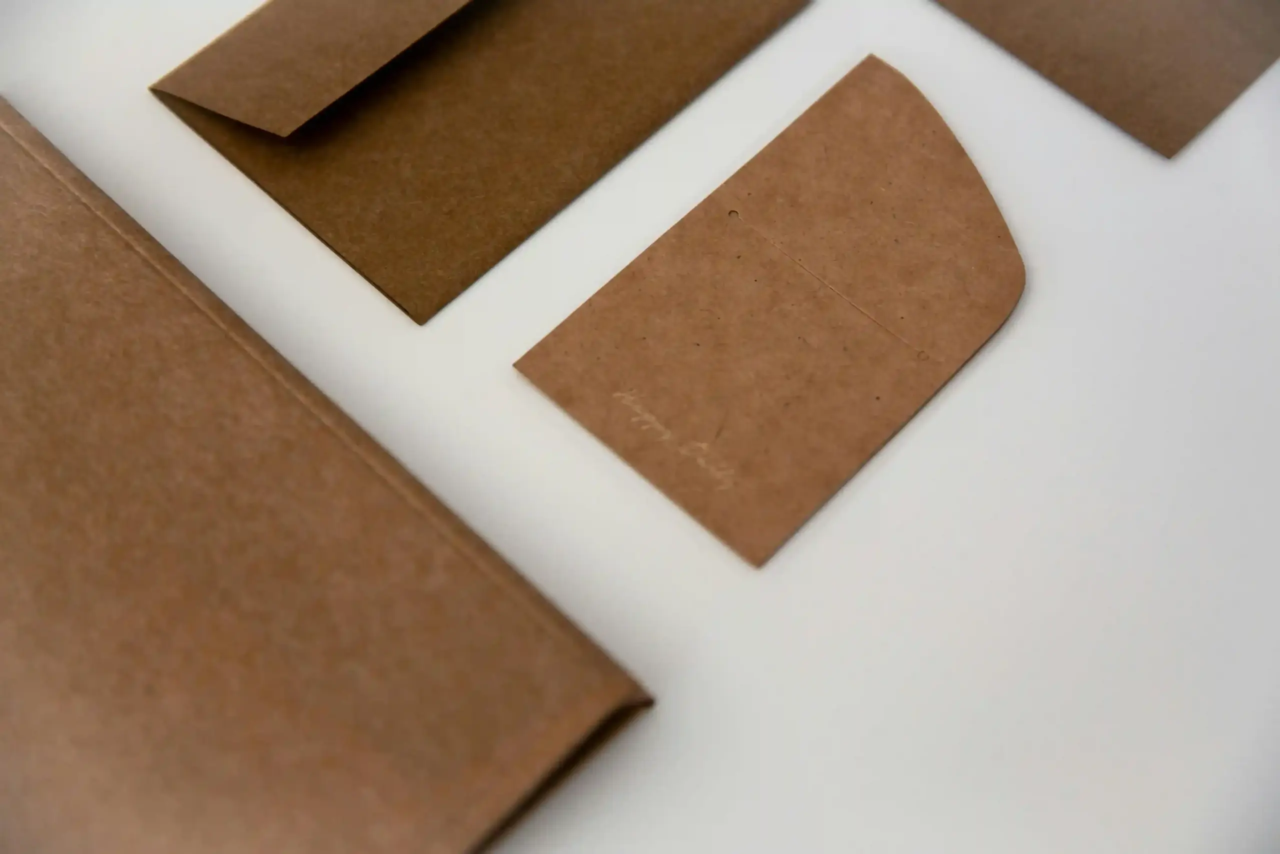 Los mejores materiales para crear merchandising sostenible Varios papeles reciclado sobre una superficie blanca
