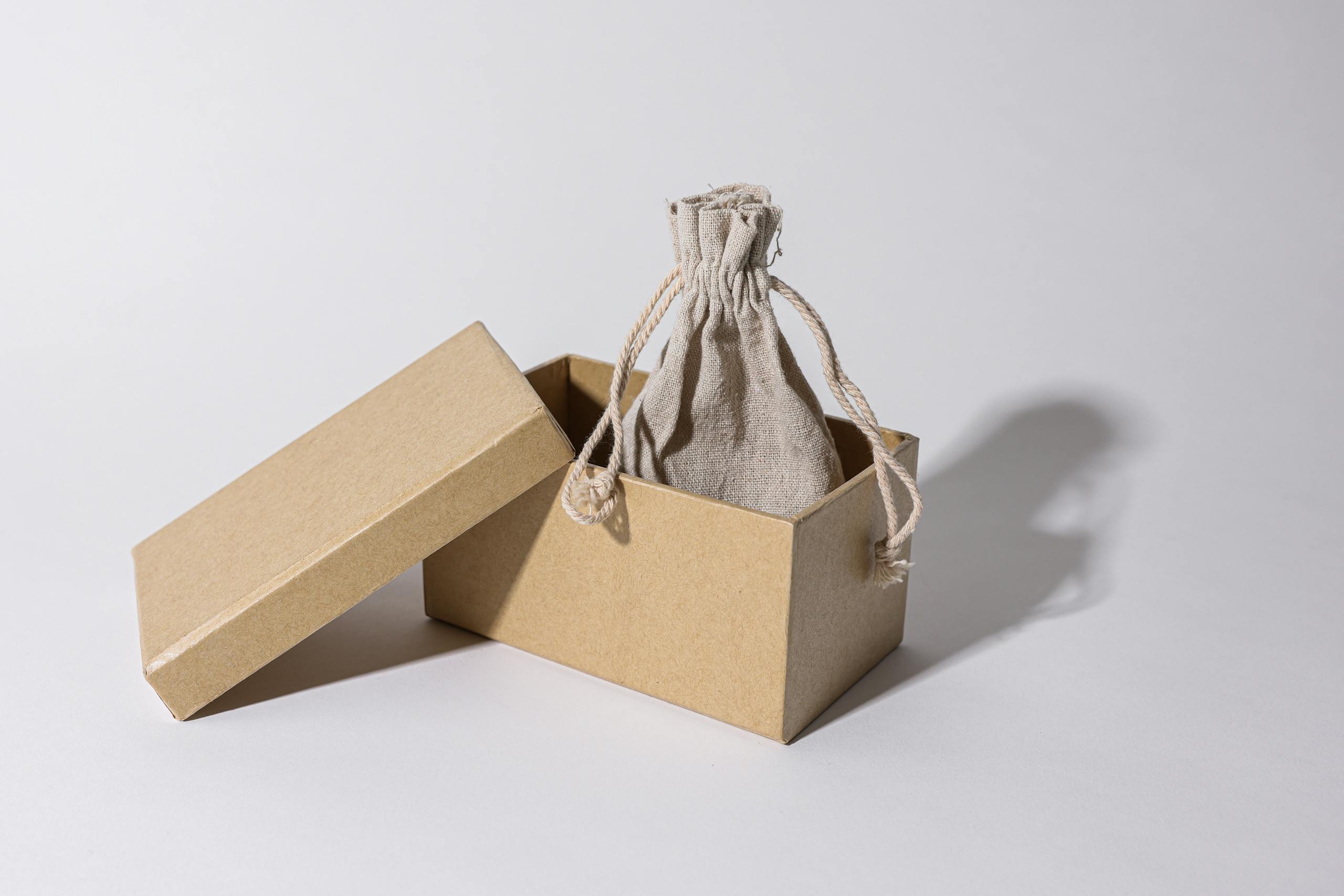 Caja de madera abierta con una bolsa de tele ecológica gris dentro