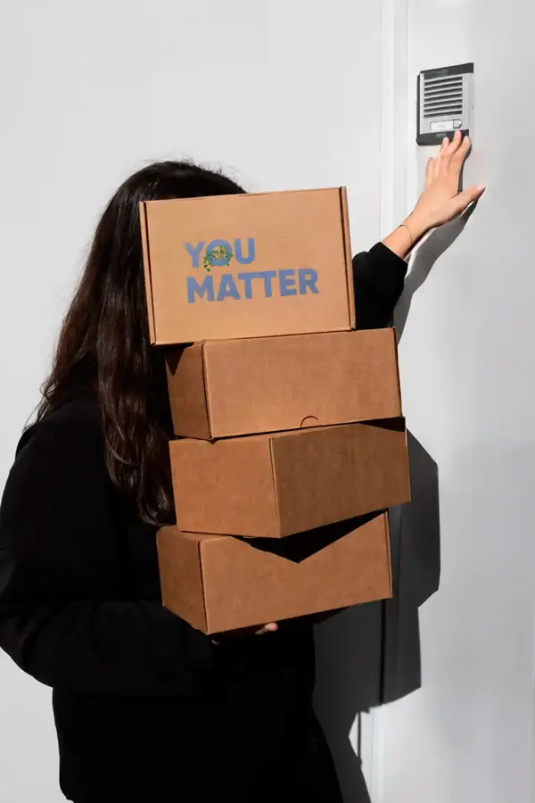 Welcome pack personalizado 'You matter' Chica cargando 4 cajas de cartón personalizadas para welcome packs de empresa