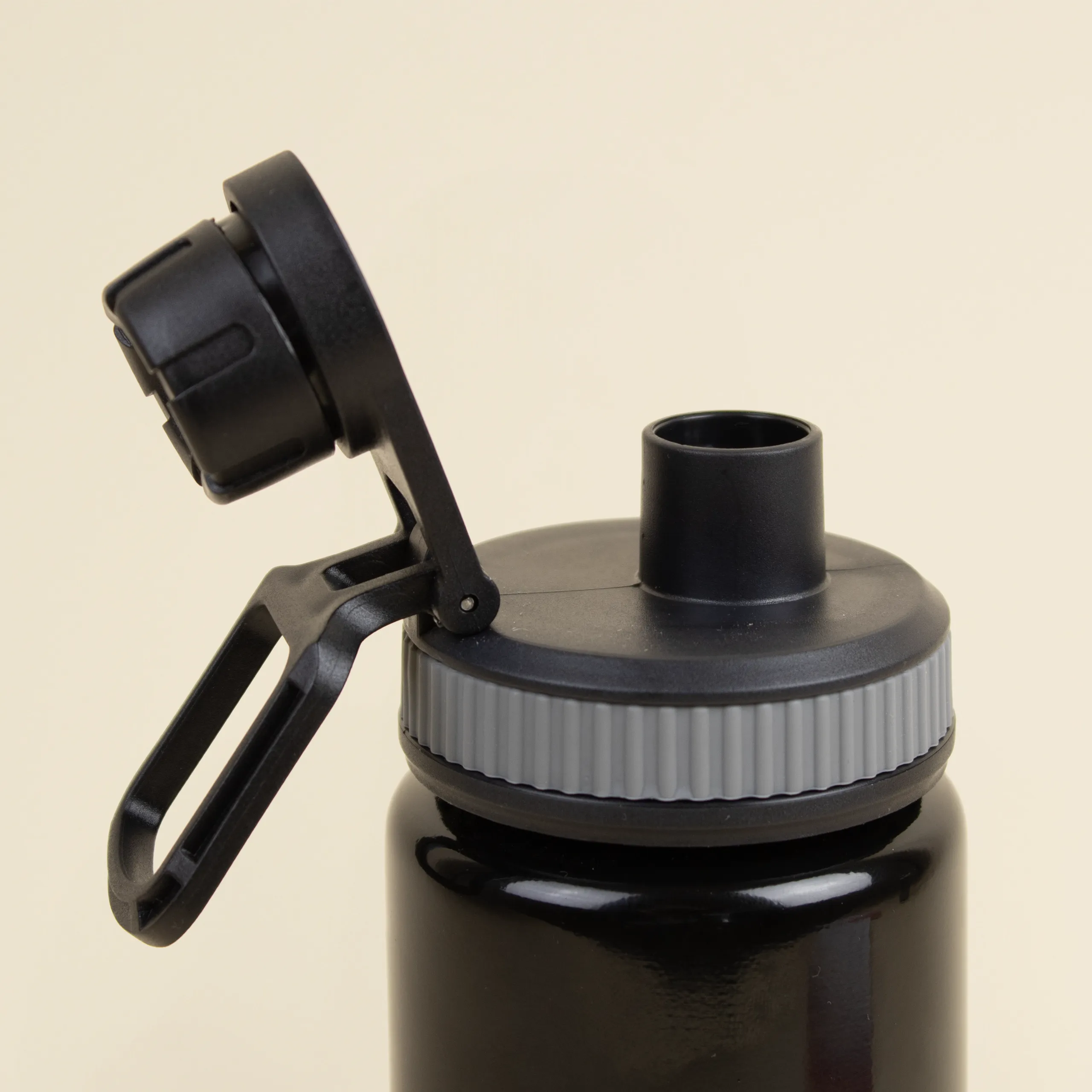 Botella deportiva personalizada BIBO Boquilla de una botella deportiva negra personalizada en aluminio reciclado sobre un fondo beige