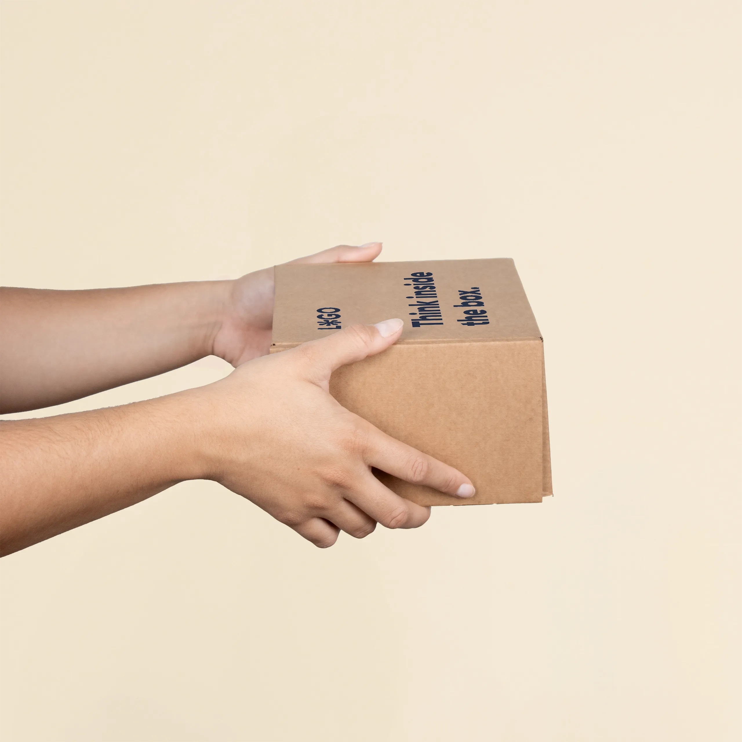 Manos sosteniendo una caja S personalizada a un color sobre un fondo beige
