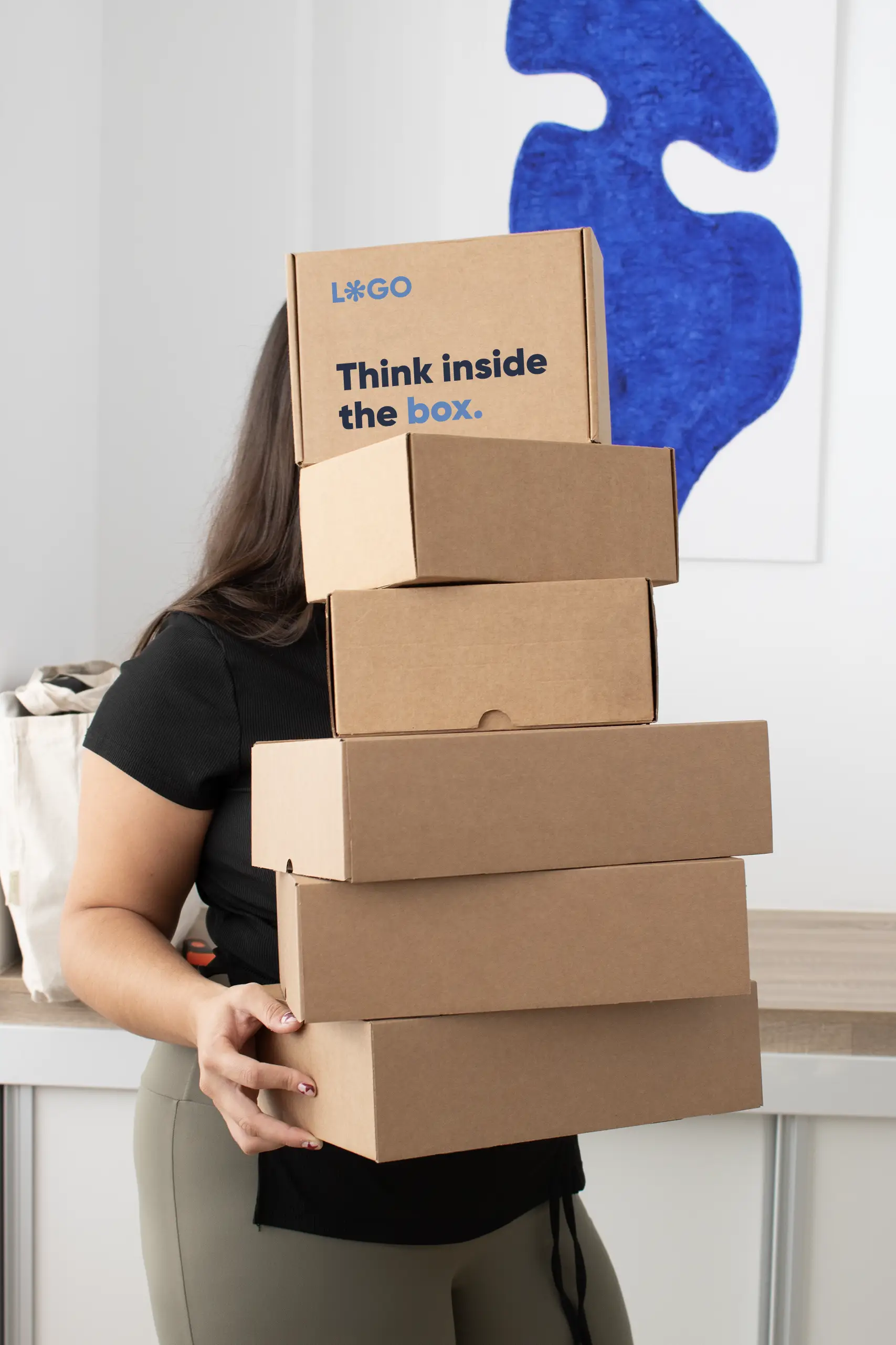 Cajas ecológicas personalizadas Chica sosteniendo una torre de cajas ecológicas personalizadas