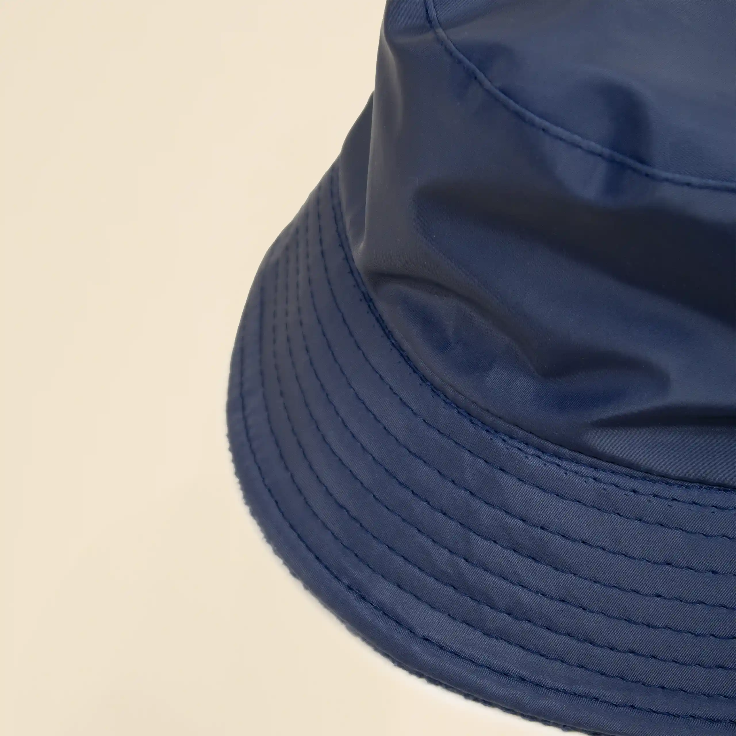 Gorro TWIST azul Gorro azul impermeable reversible ecológico personalizado sobre un fondo beige