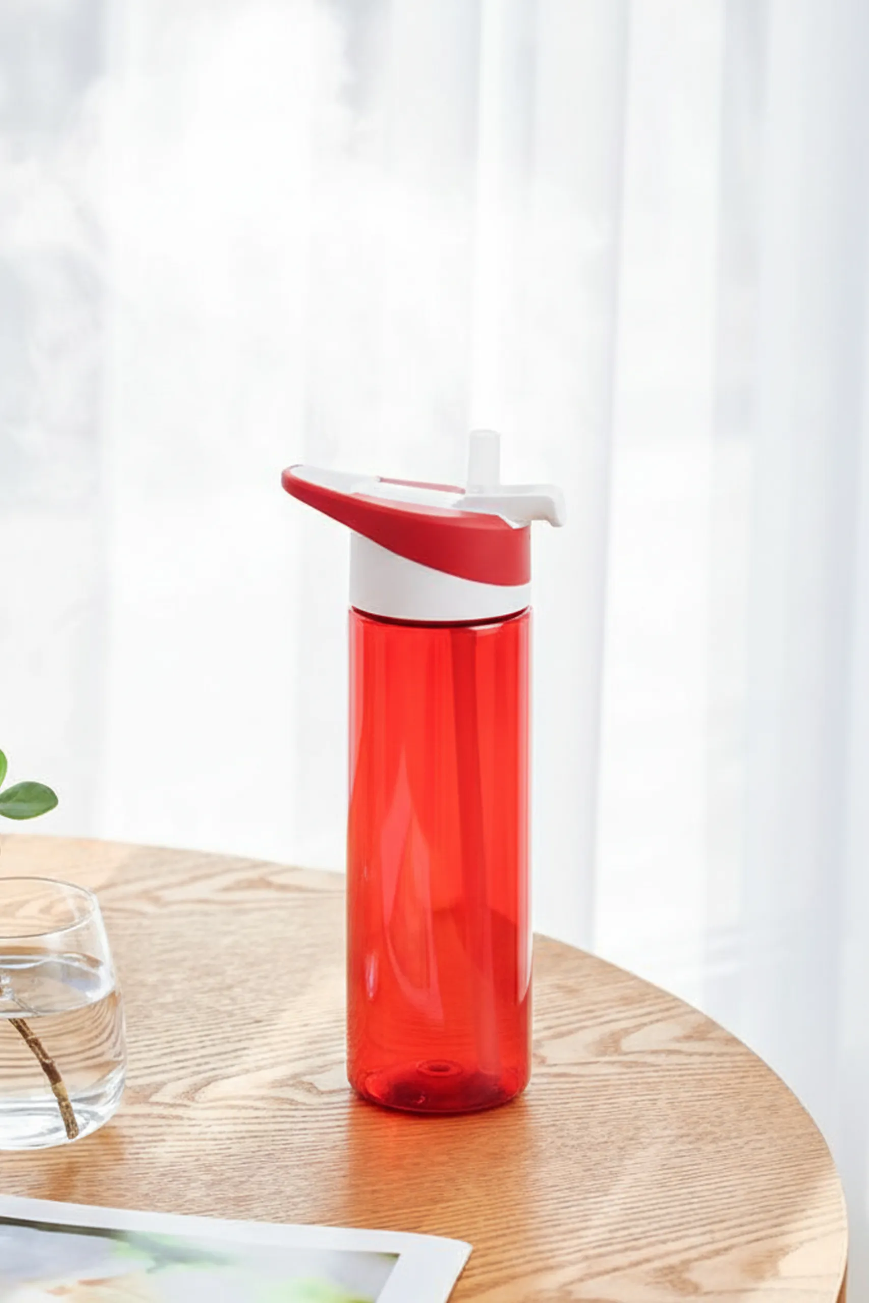 Botella de gimnasio personalizada LEMOS Botella de gimnasio roja sobre una mesa de madera