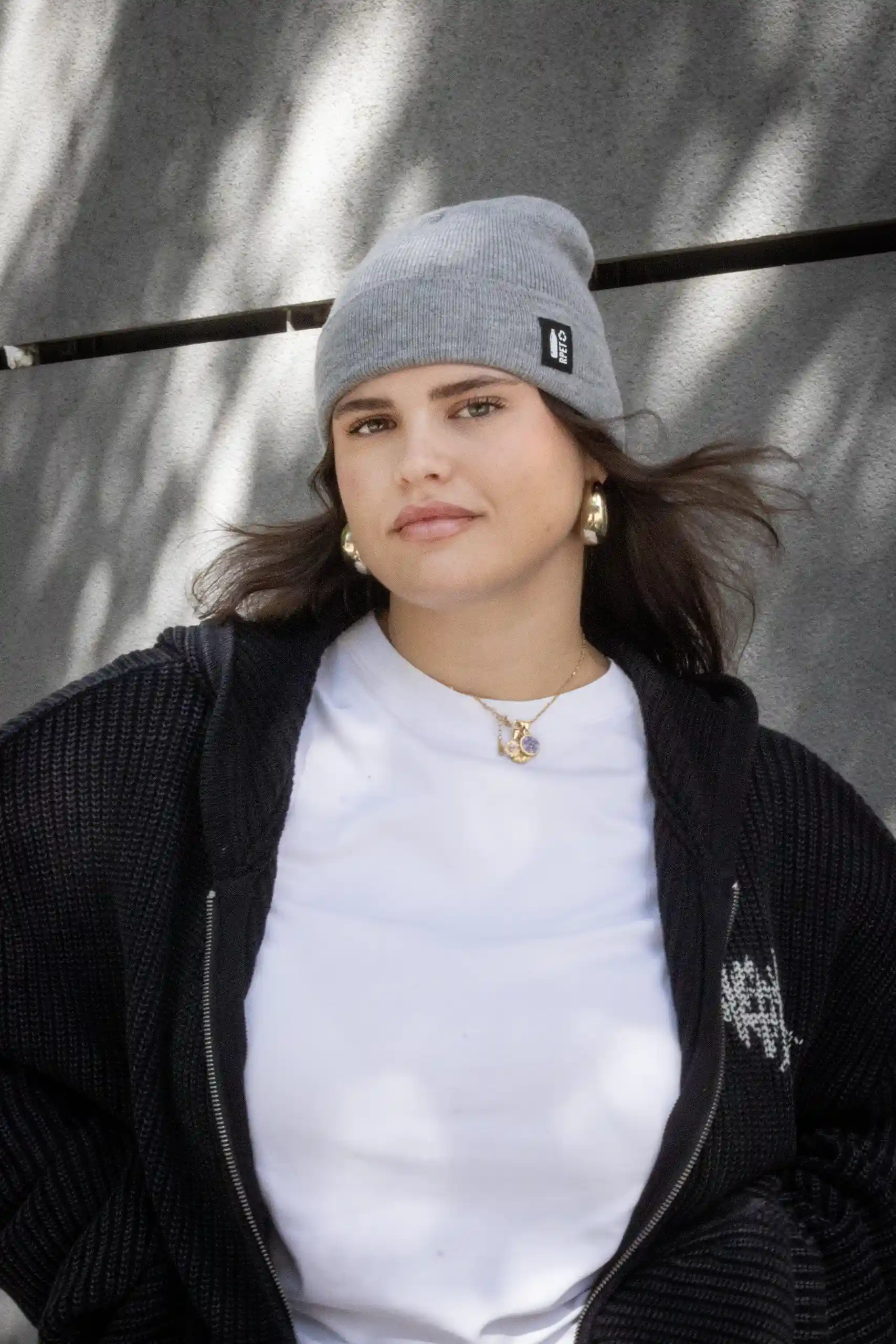 Chica mirando a cámara con gorro gris ecológico personalizado