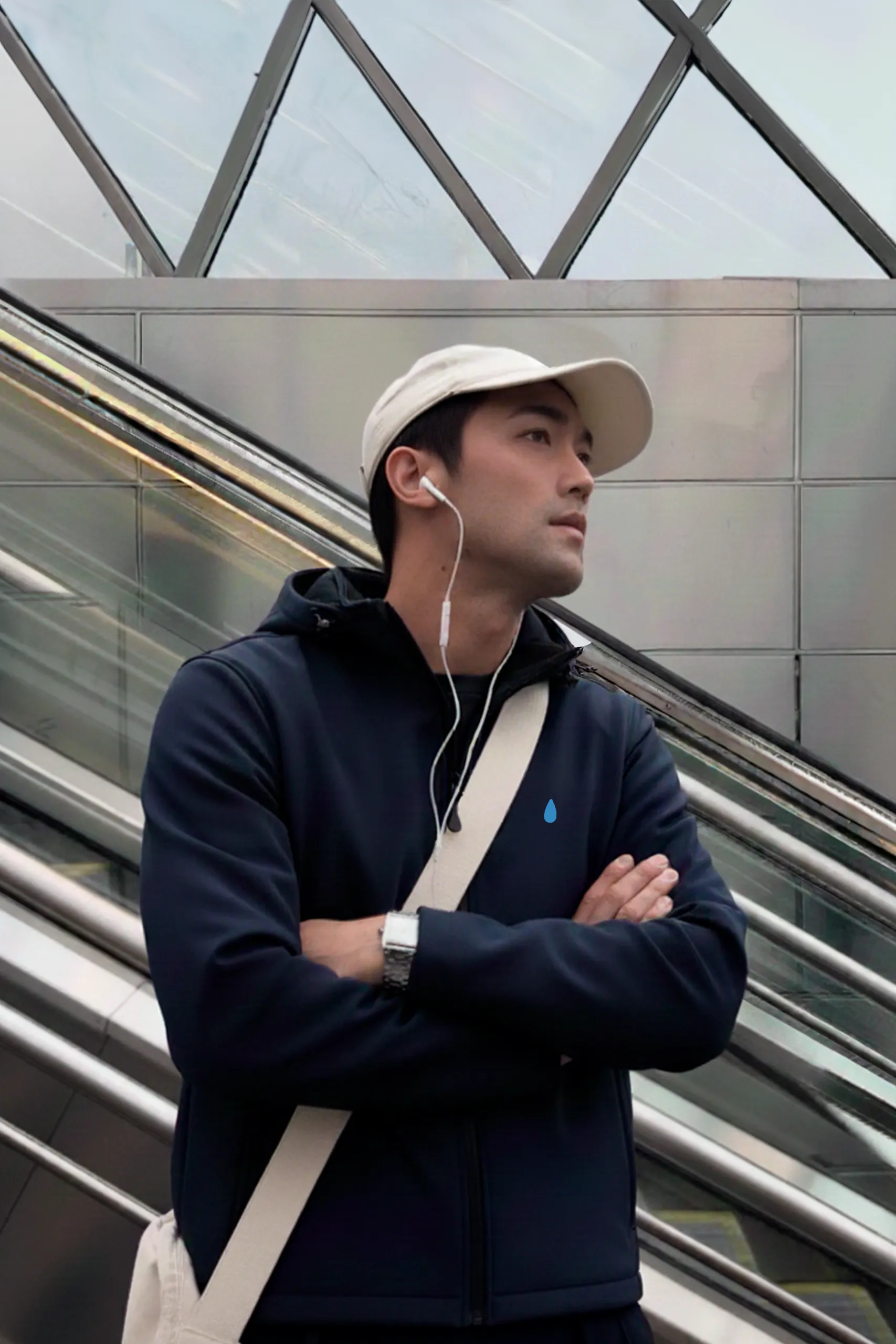 Chico con chaqueta personalizada azul con capucha escuchando música