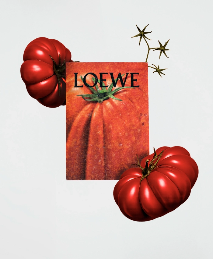 Tarjeta roja impresa en papel plantable con personalización de la marca de Loewe, junto a dos tomates