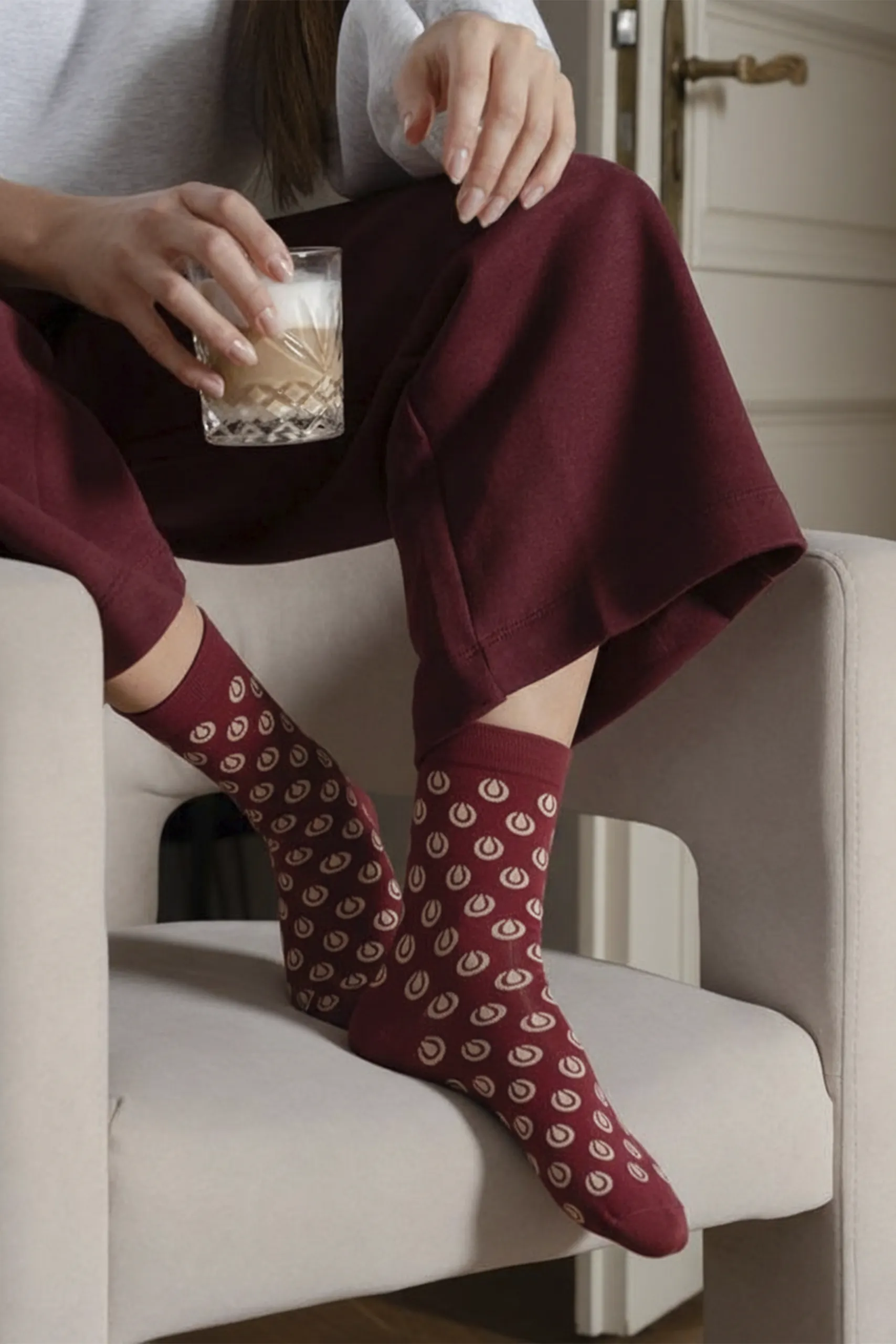 Custom socks LION Chica con un café sobre una silla con calcetines rojos personalizados