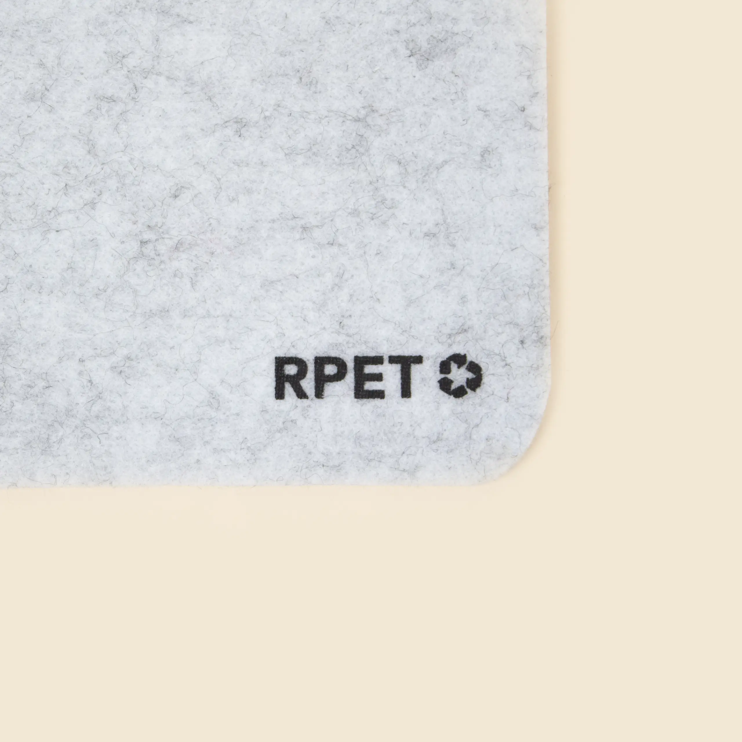 Alfombrilla de fieltro personalizada MOVA Detalle de la palabra "RPET" impresa en negro en la esquina inferior derecha de una alfombrilla de ordenador de fieltro gris