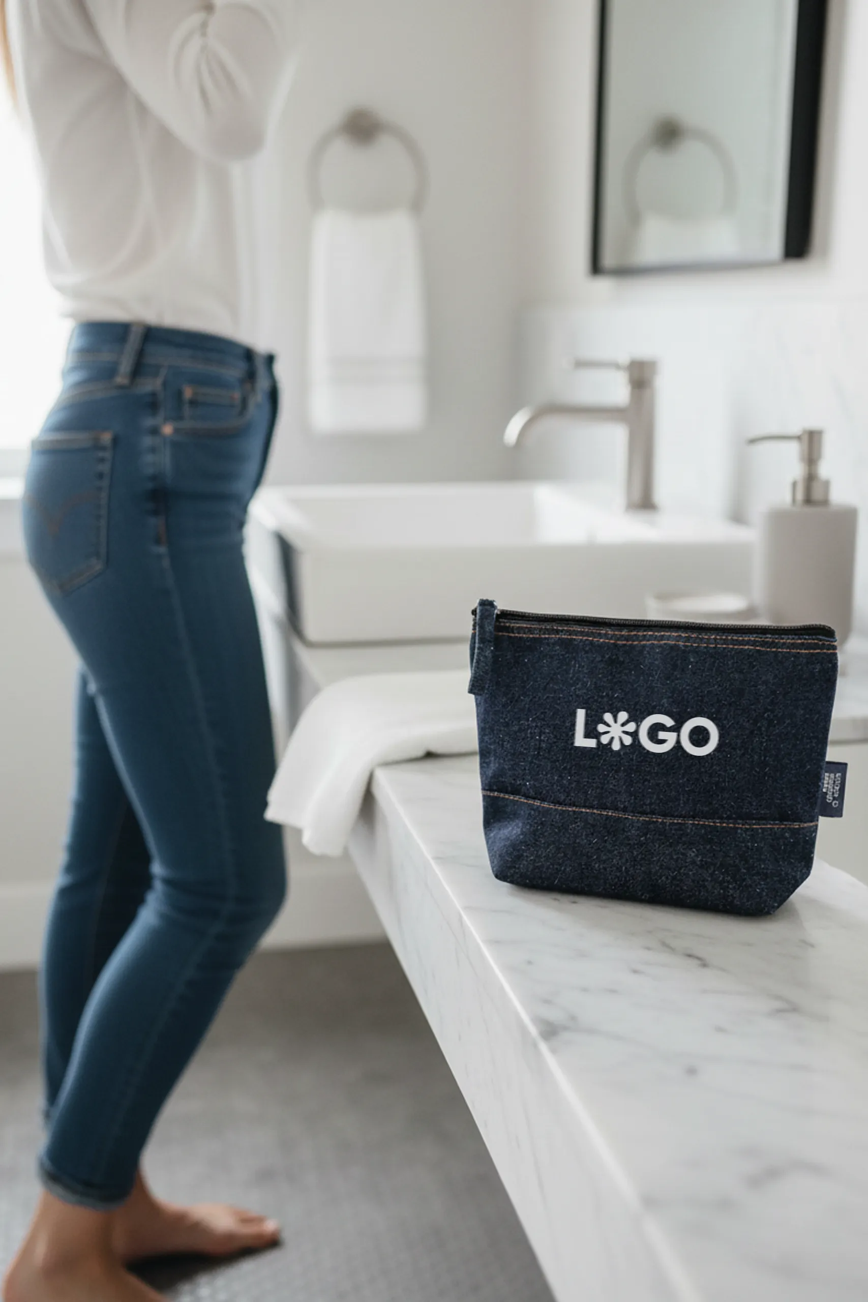 Neceser de vaquero personalizado con la palabra 'logo' en blanco apoyado en una encimera